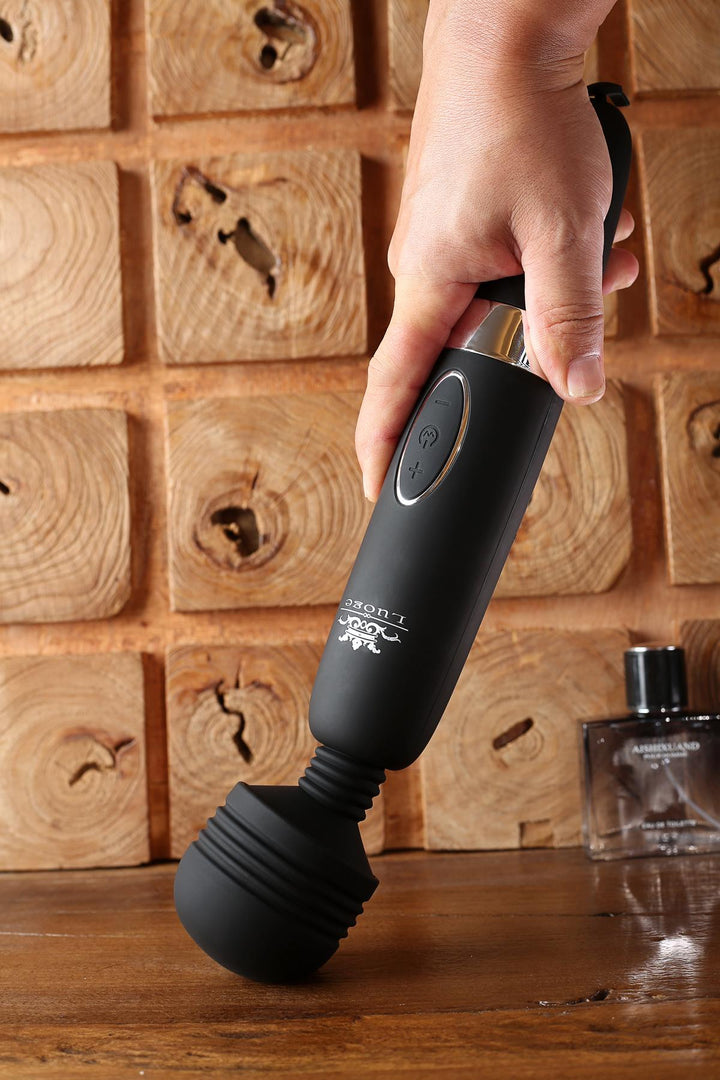Hand hält schwarzen Massagestab