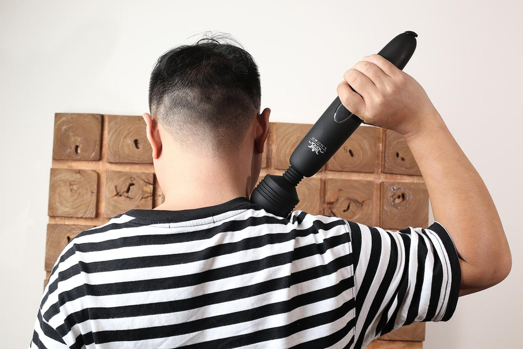 Person mit Massagegerät am Rücken